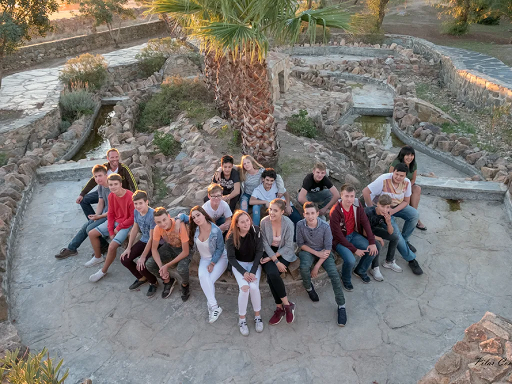 Die Reisegruppe sitzt auf breiten Steinstufen in einem Park.